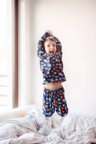 Garçon Pyjama Avec Des Dessins Spatiaux Saute Sur Lit Exercices — Photo