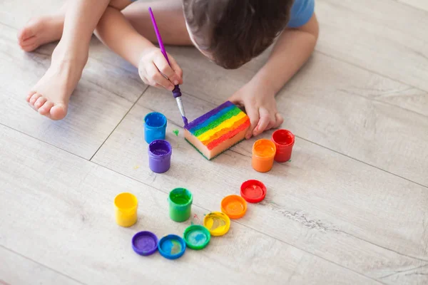 Kleiner Junge Zeichnet Einen Regenbogen Auf Ein Blatt Papier Verschiedenen — Stockfoto