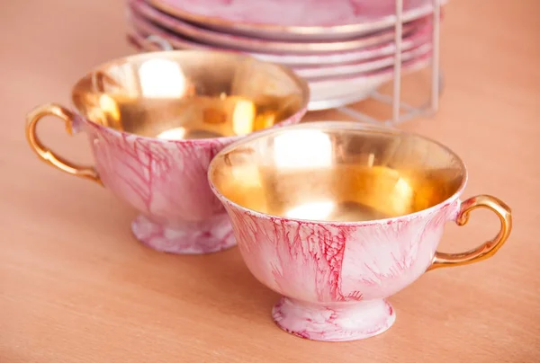 De roze en gouden set porselein van kopjes — Stockfoto