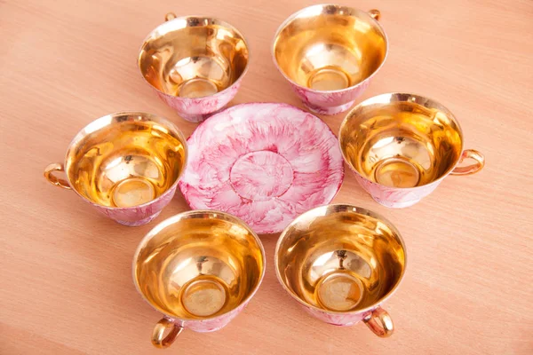 Rosa de porcelana e conjunto dourado de copos — Fotografia de Stock