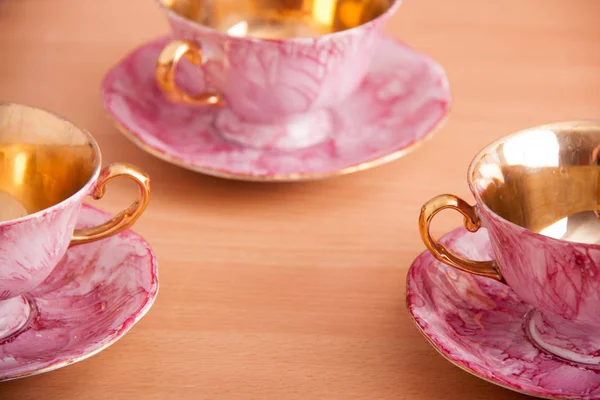 De roze en gouden set porselein van kopjes — Stockfoto