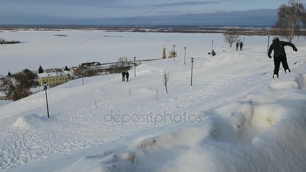 Snowboarder έρχεται κάτω από το χιονισμένο πίστες για Fedorovsky ανάχωμα στο Νίζνι Νόβγκοροντ — Αρχείο Βίντεο