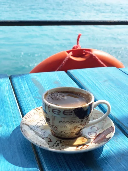 Greek coffee on a blue wooden table against the background of the sea in Crete