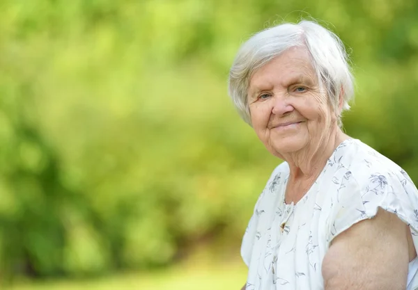 Senior vrouw die lacht in park. — Stockfoto