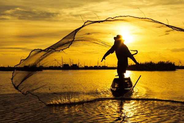 Gün doğumu saatinde net balıkçılık atarken Siluet Fisherman eylem