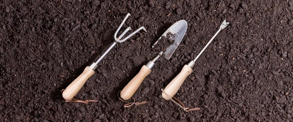 Tres pequeñas herramientas de jardín en el suelo —  Fotos de Stock