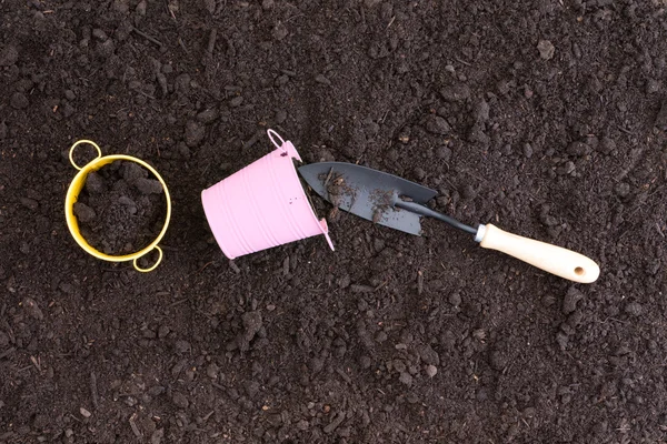 풍부한 검은 토양에 있는 작은 분홍색과 노란색 pails — 스톡 사진
