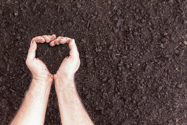 Pair of hands holding soil in heart shape — Stock Photo, Image