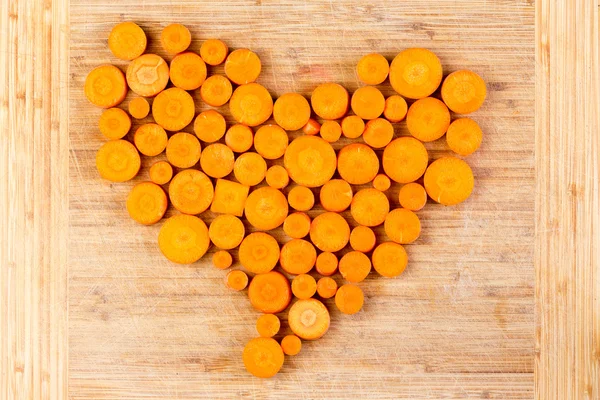 Świeżo pokrojone marchewki pomarańczowy rozmieszczone w serce — Zdjęcie stockowe
