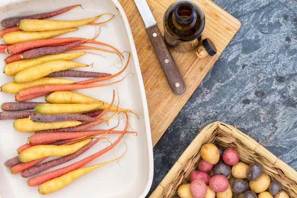 Bunte Möhren und Kartoffeln mit Schneidebrett — Stockfoto