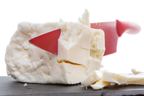 Faca de cerâmica vermelha cortando através de queijo feta — Fotografia de Stock
