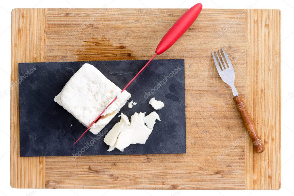 Red knife cutting feta cheese