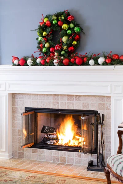 Karácsonyi baubles és a lángoló tűz kandalló — Stock Fotó