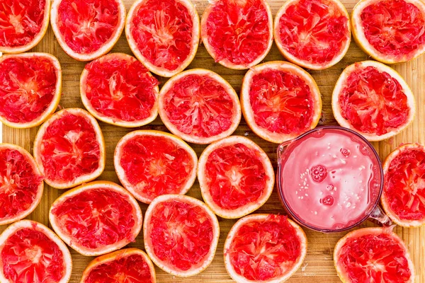 Heerlijke ruby red grapefruit helften door glas — Stockfoto