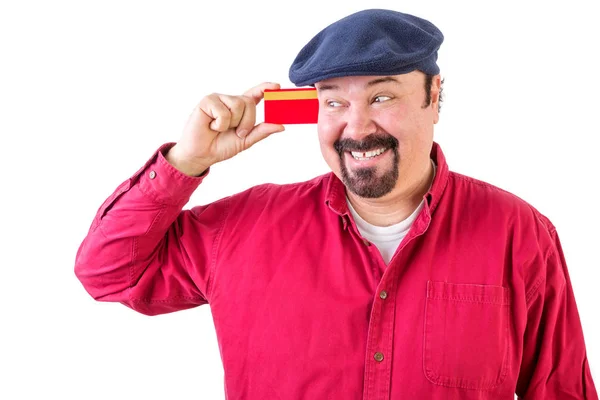Gleeful man eyeing his credit card with a smile — Stock Photo, Image