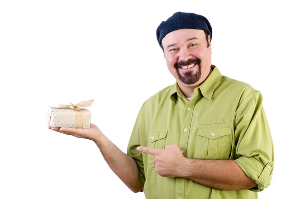 Усміхнений чоловік у береті тримає загорнутий подарунок на білому — стокове фото