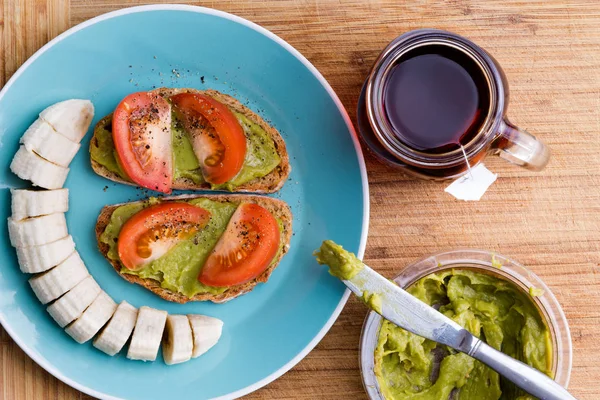 Power Breakfast with Chunky Guacamole, sliced Bananas and Te — Stock Photo, Image