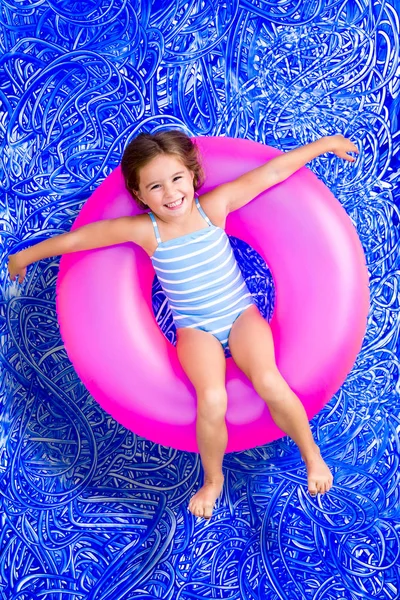 Happy young girl floating in a summer pool — Stock Photo, Image