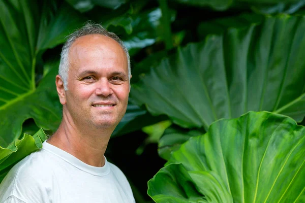 Attractive middle-aged man with Philodendron — Stock Photo, Image