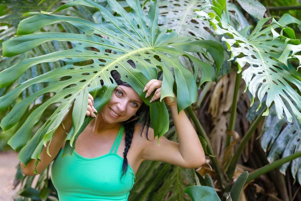 Söt lekfull kvinna kikar ut från under ett blad — Stockfoto