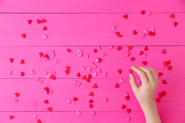Verspreide rode harten op een lichte roze achtergrond — Stockfoto