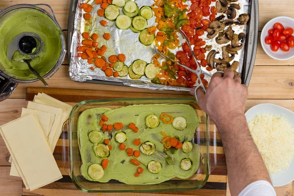 Männlicher Koch bereitet eine Gemüse-Lasagne zu — Stockfoto