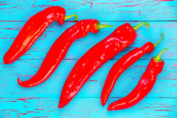 Diagonal line of fresh red hot chili peppers — Stock Photo, Image