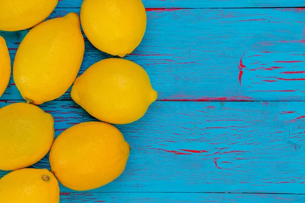 Limones amarillos maduros jugosos sobre un fondo de madera azul —  Fotos de Stock