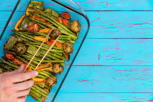 Chef serving a dish of fresh roast vegetables — Stock Photo, Image