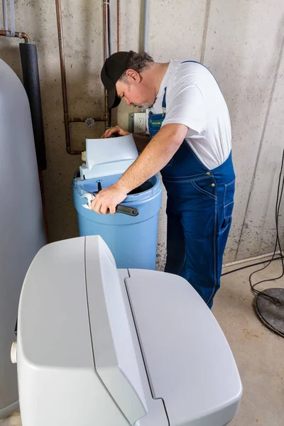 Workman installing a domestic water softener — Stock Photo, Image