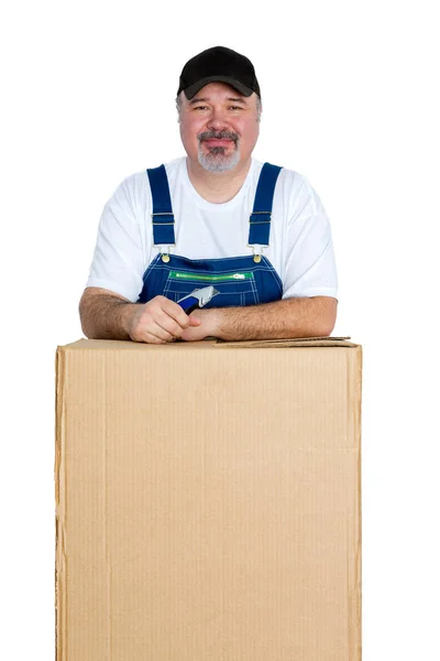 Sorrindo homem de pé sobre grande caixa de papelão — Fotografia de Stock