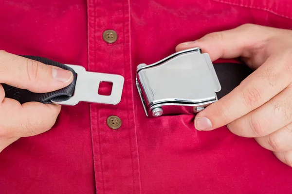 Male passenger on a plane buckling up a seatbelt — Stock Photo, Image