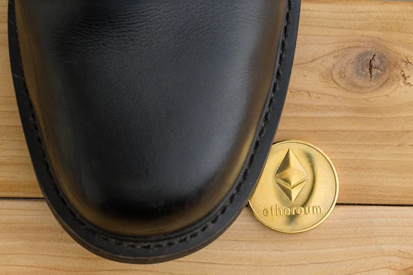 Single Ethereum cryptocurrency coin under a shoe — Stock Photo, Image