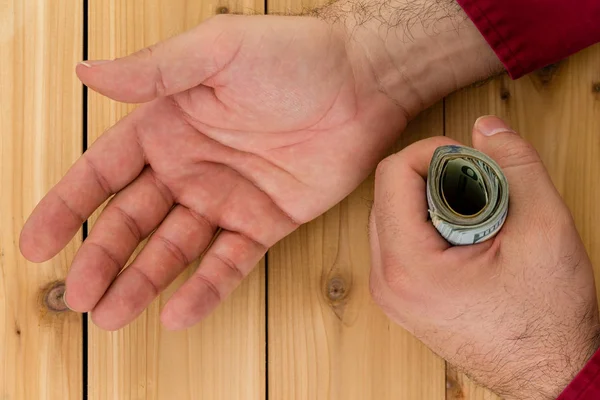 Man hålla tuss av sedlar samtidigt be om mer — Stockfoto