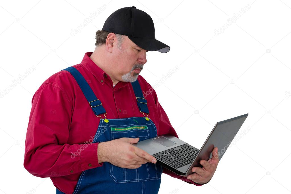 Man wearing dungarees holding laptop