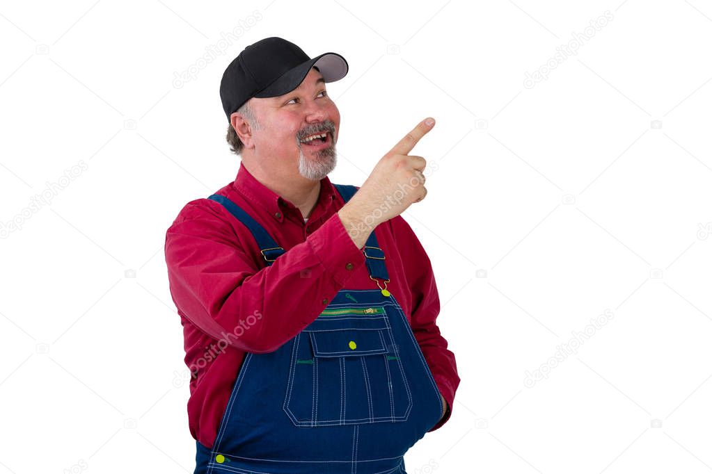 Pleased happy man in denim dungarees pointing up