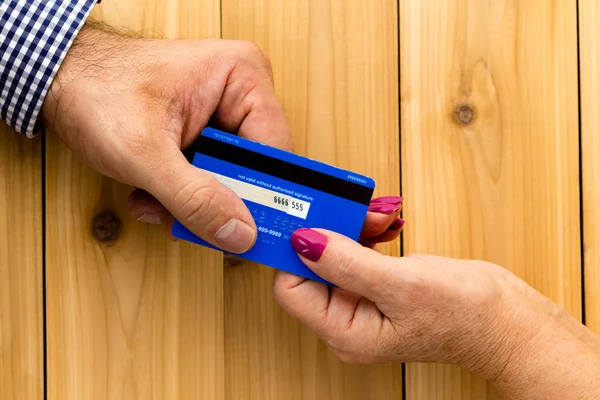 Nahaufnahme einer männlichen Hand, die einer Frau ihre Kreditkarte gibt — Stockfoto