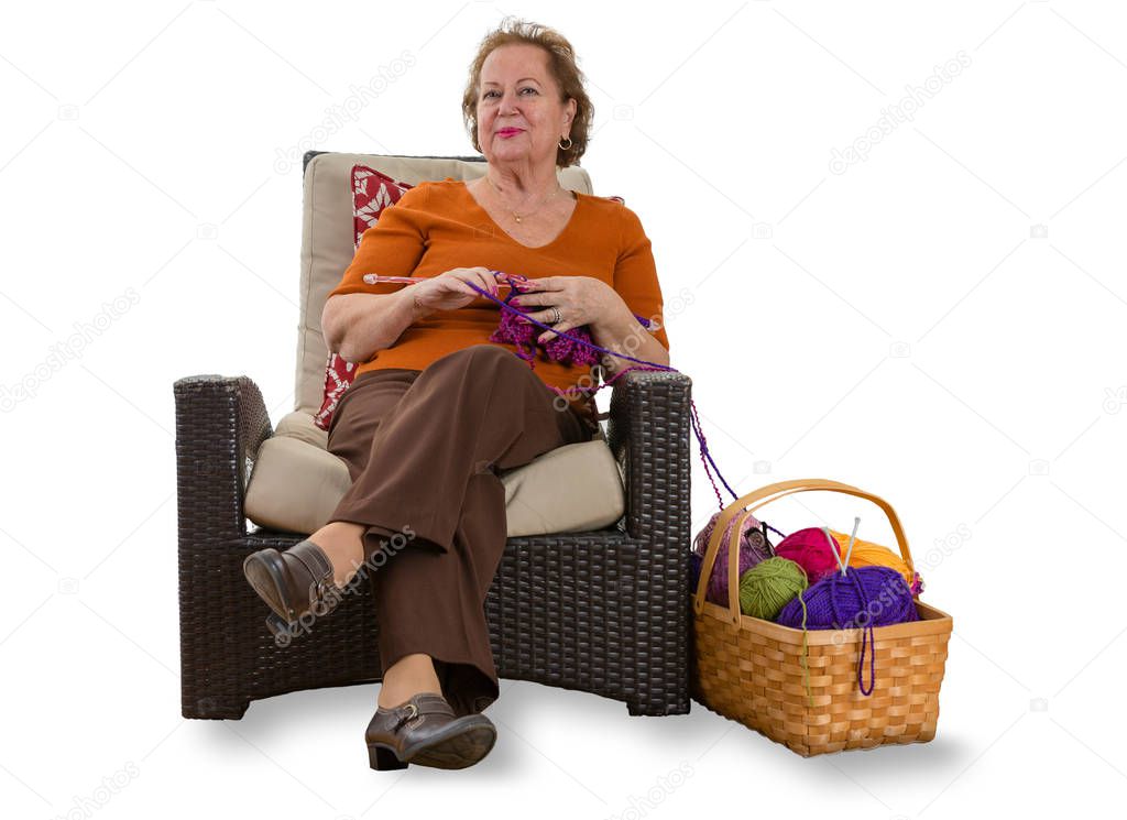 Happy elderly lady relaxing in a wicker chair