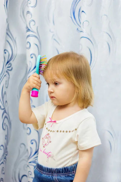 Küçük kız bir saç fırçası saç tarak — Stok fotoğraf