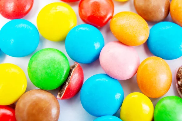 Muitas pílulas de doces redondas pequenas e multicoloridas estão espalhadas na mesa, vista superior — Fotografia de Stock