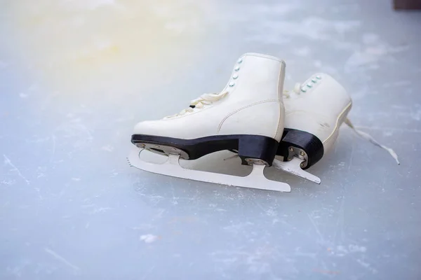 Un par de patines femeninos rizados se encuentran en el hielo en la pista — Foto de Stock