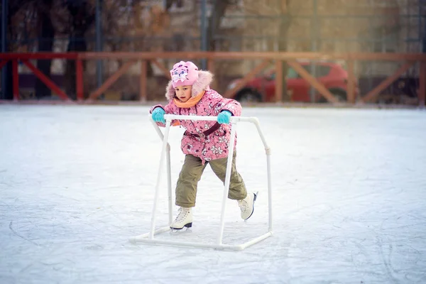 Patines infantiles felices en una pista de hielo con un soporte especial — Foto de Stock