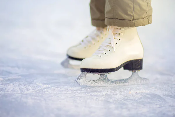 Uma criança em patins figura fica no gelo, patins close-up . — Fotografia de Stock