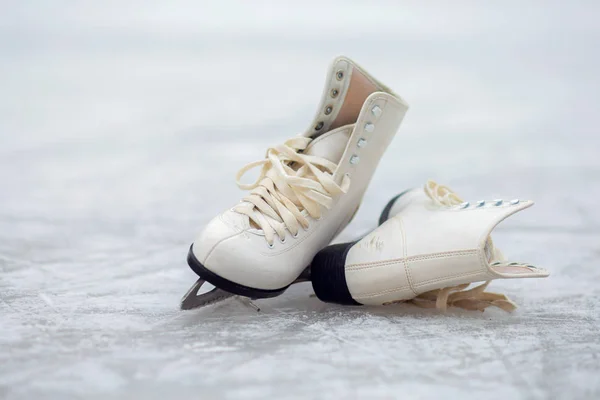 White figure skates lie on an open ice rink — Stock Photo, Image
