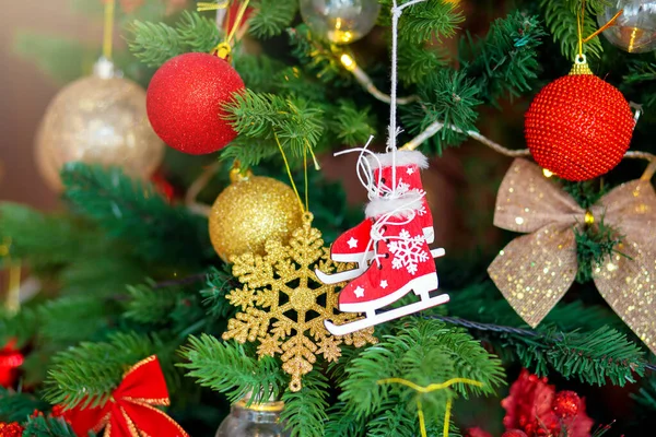 Décoration d'arbre de Noël. Jouet en bois patins rouges sur une branche close-up — Photo
