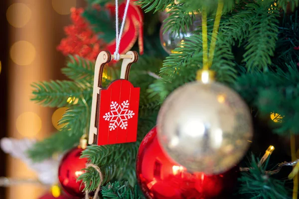 Décoration d'arbre de Noël. Jouet en bois traîneau rouge sur une branche close-up — Photo