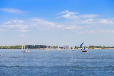 Sailing regatta is on the Volga River near the city of Volgograd. Many yachts with sails on the water