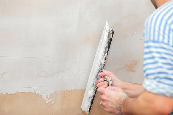 Reparação dos alojamentos. Putty paredes interiores com uma espátula de metal largo — Fotografia de Stock
