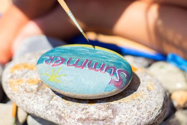 Plaj taşlarına resim çizerek. Yazın suluboya yapmak