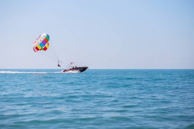Denizin ortasındaki bir tekneden turistlerle paraşüt fırlatmak. Sahil Seyahati Eğlencesi.